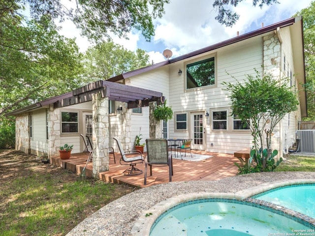 16930 Hidden Timber Wood, San Antonio, TX 78248 - back of property with a wooden deck, central AC, outdoor dining area, and a pool with connected hot tub