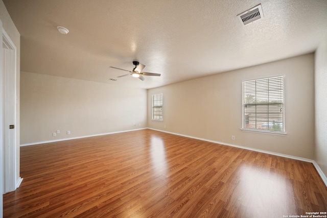 7731 Cedar Farm, San Antonio, TX 78239 - empty room with light wood-style floors, ceiling fan, baseboards, a textured ceiling, and a smoke detector