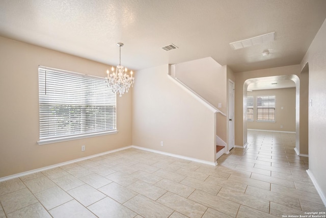 7731 Cedar Farm, San Antonio, TX 78239 - unfurnished room with arched walkways, a chandelier, stairs, baseboards, and a textured ceiling