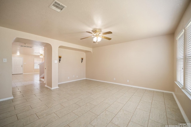 7731 Cedar Farm, San Antonio, TX 78239 - spare room featuring a ceiling fan, arched walkways, stairway, and healthy amount of natural light