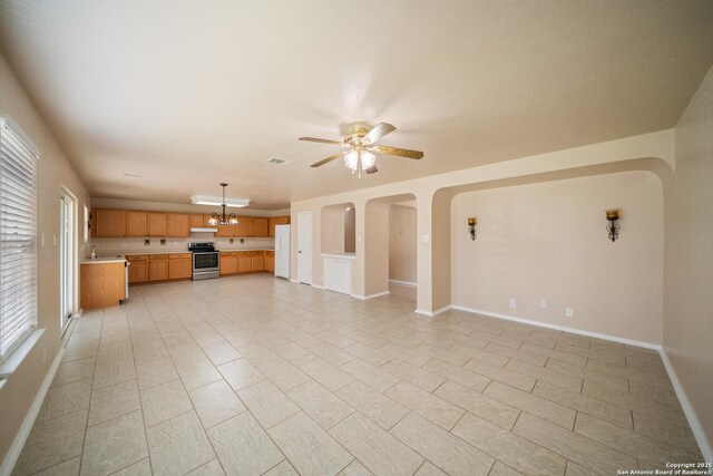 7731 Cedar Farm, San Antonio, TX 78239 - unfurnished living room with ceiling fan, arched walkways, baseboards, a chandelier, and a sink