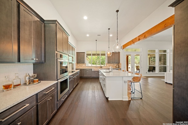 117 Sabella, Spring Branch, TX 78070 - kitchen with appliances with stainless steel finishes, a breakfast bar, dark wood-style floors, tasteful backsplash, and a sink
