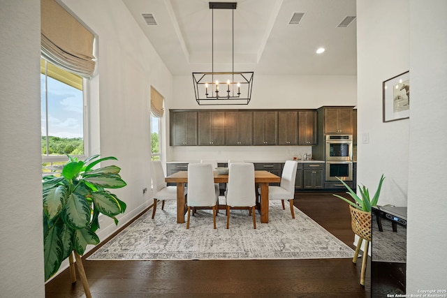 117 Sabella, Spring Branch, TX 78070 - dining space featuring a chandelier, dark wood-style flooring, a towering ceiling, and baseboards