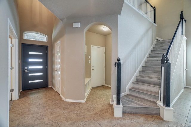 6763 Indian Ldg, San Antonio, TX 78253 - foyer with arched walkways, stairs, light tile patterned flooring, and baseboards