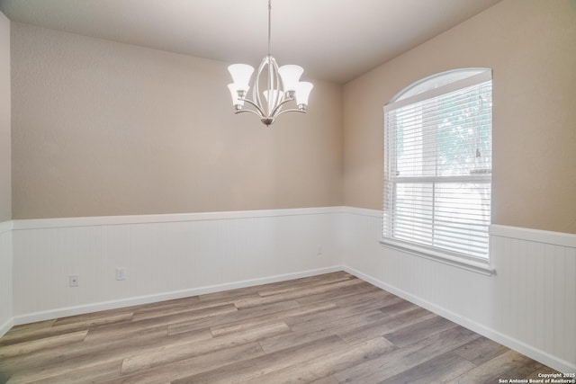6763 Indian Ldg, San Antonio, TX 78253 - unfurnished room with wainscoting, light wood finished floors, and a chandelier