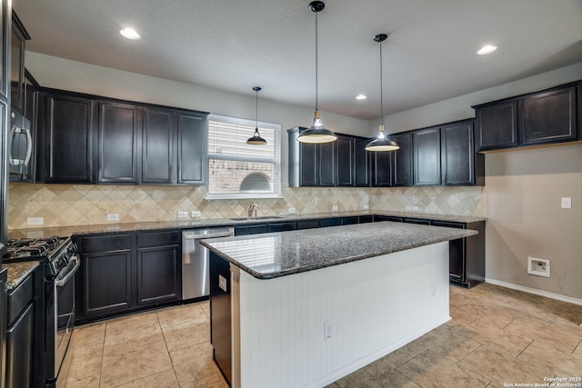 6763 Indian Ldg, San Antonio, TX 78253 - kitchen with appliances with stainless steel finishes, a sink, dark stone counters, decorative backsplash, and a center island