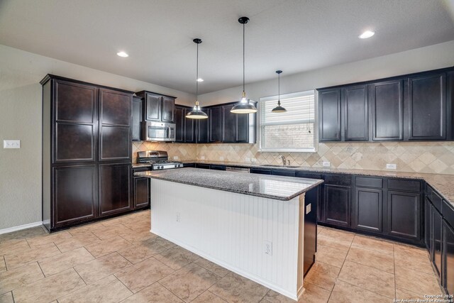 6763 Indian Ldg, San Antonio, TX 78253 - kitchen featuring stainless steel appliances, a sink, light stone countertops, decorative backsplash, and a center island