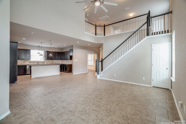 6763 Indian Ldg, San Antonio, TX 78253 - unfurnished living room featuring a towering ceiling, ceiling fan, light tile patterned floors, and baseboards
