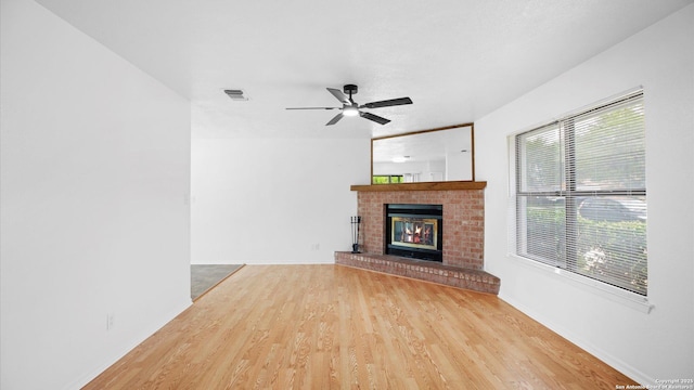 218 Gruene, New Braunfels, TX 78130 - unfurnished living room featuring light wood finished floors, a ceiling fan, and a fireplace