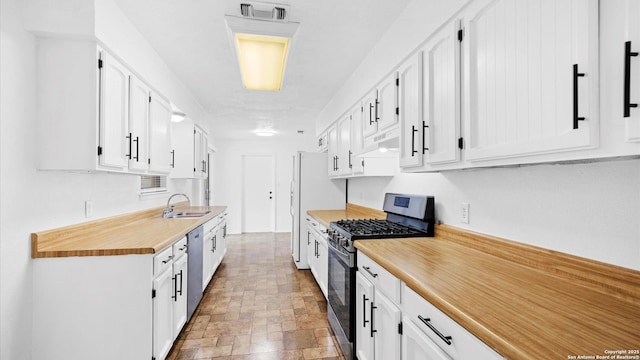 218 Gruene, New Braunfels, TX 78130 - kitchen featuring stainless steel appliances, light countertops, white cabinets, under cabinet range hood, and stone finish floors