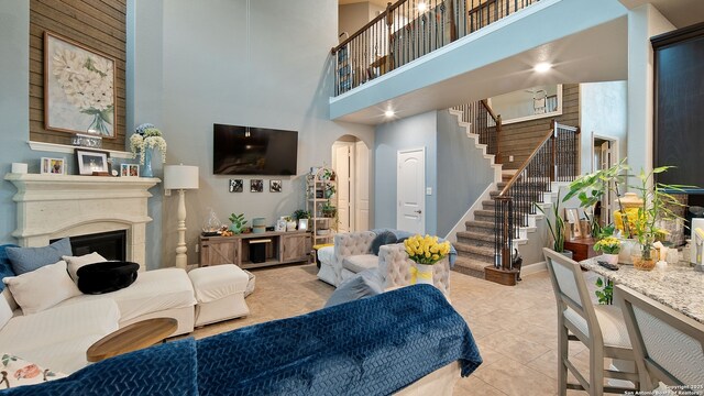 32337 Lavender Cv, Bulverde, TX 78163 - living area featuring a towering ceiling, stairway, arched walkways, a fireplace, and light tile patterned floors