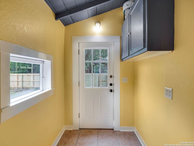 1211 W Magnolia Ave, San Antonio, TX 78201 - entryway with lofted ceiling, light tile patterned flooring, baseboards, and a textured wall