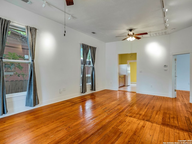 1211 W Magnolia Ave, San Antonio, TX 78201 - empty room featuring track lighting, ceiling fan, wood-type flooring, and baseboards