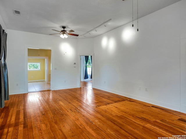 1211 W Magnolia Ave, San Antonio, TX 78201 - empty room featuring ceiling fan, track lighting, plenty of natural light, and wood-type flooring