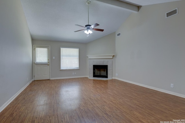 5711 Timberhurst, San Antonio, TX 78250 - unfurnished living room featuring a ceiling fan, wood finished floors, and a tiled fireplace