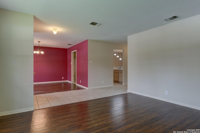 5711 Timberhurst, San Antonio, TX 78250 - spare room with wood finished floors and a chandelier