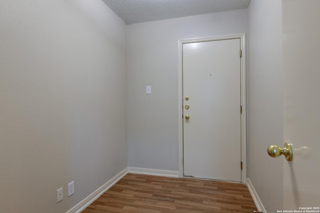 5711 Timberhurst, San Antonio, TX 78250 - doorway featuring light wood-style floors and a textured ceiling