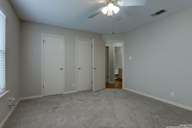 5711 Timberhurst, San Antonio, TX 78250 - unfurnished bedroom with two closets, carpet, and ceiling fan