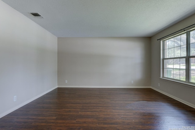 5711 Timberhurst, San Antonio, TX 78250 - unfurnished room featuring dark wood-style flooring and a textured ceiling
