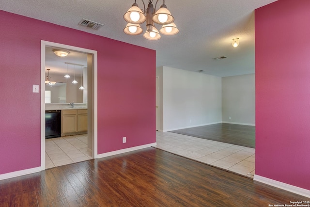 5711 Timberhurst, San Antonio, TX 78250 - empty room featuring wood finished floors, a chandelier, and a textured ceiling