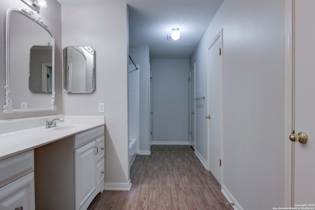 5711 Timberhurst, San Antonio, TX 78250 - bathroom featuring vanity, wood finished floors, shower / tub combination, and a textured ceiling