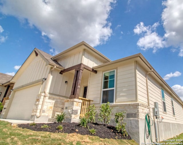 468 Salz Way, San Antonio, TX 78260 - view of front of property featuring stone siding, an attached garage, a front lawn, and board and batten siding