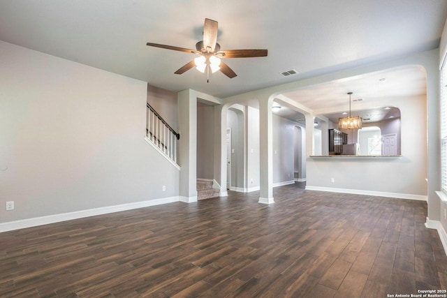 7030 Plains Way, San Antonio, TX 78253 - unfurnished living room featuring arched walkways, dark wood-style floors, ceiling fan, a chandelier, and baseboards