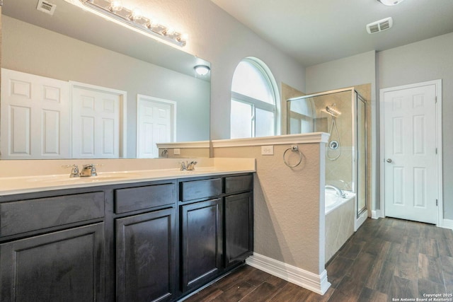 7030 Plains Way, San Antonio, TX 78253 - bathroom featuring a shower stall, wood finished floors, double vanity, a bath, and baseboards