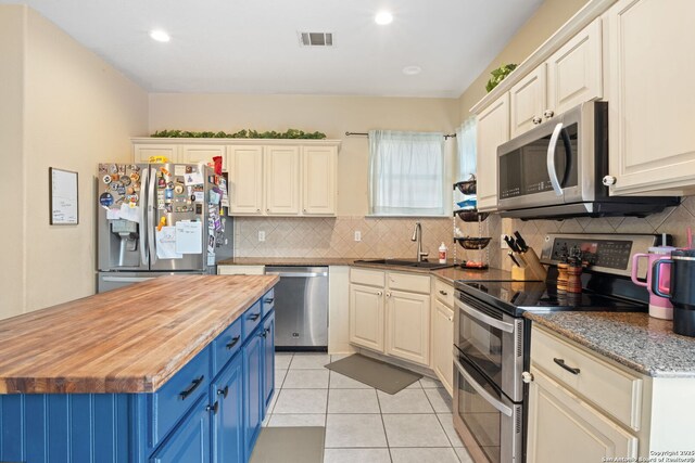 815 Maltese Gdn, San Antonio, TX 78260 - kitchen featuring stainless steel appliances, blue cabinetry, wooden counters, a sink, and backsplash