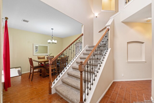 815 Maltese Gdn, San Antonio, TX 78260 - stairway featuring baseboards, wood finished floors, a chandelier, and a towering ceiling
