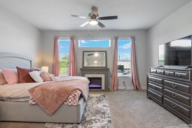 8851 Oakland Rd, San Antonio, TX 78240 - carpeted bedroom with multiple windows, a stone fireplace, baseboards, and a ceiling fan