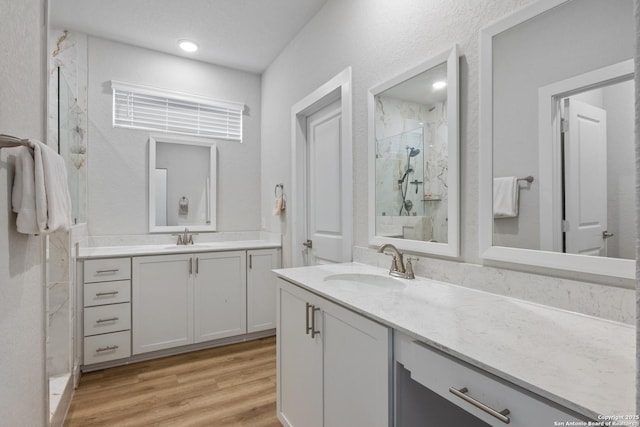 8851 Oakland Rd, San Antonio, TX 78240 - full bathroom featuring a marble finish shower, two vanities, and wood finished floors