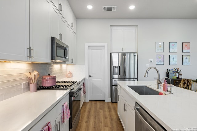 8851 Oakland Rd, San Antonio, TX 78240 - kitchen featuring stainless steel appliances, a sink, light countertops, white cabinetry, and recessed lighting