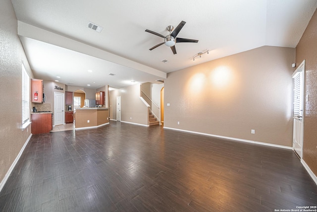10736 Gemsbuck Ldg, San Antonio, TX 78245 - unfurnished living room featuring ceiling fan, baseboards, stairway, dark wood finished floors, and vaulted ceiling
