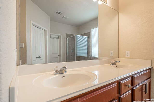 10736 Gemsbuck Ldg, San Antonio, TX 78245 - full bathroom with a textured wall, double vanity, and a shower stall
