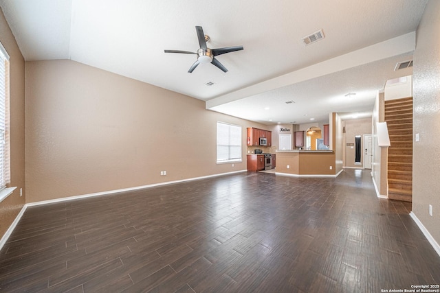 10736 Gemsbuck Ldg, San Antonio, TX 78245 - unfurnished living room featuring dark wood-style flooring, baseboards, ceiling fan, stairs, and vaulted ceiling