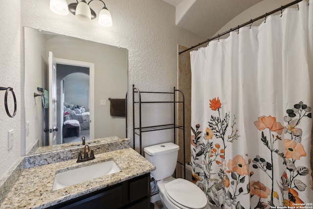 25723 Coreopsis, San Antonio, TX 78261 - bathroom featuring a textured wall, vanity, toilet, a shower with shower curtain, and ensuite bath