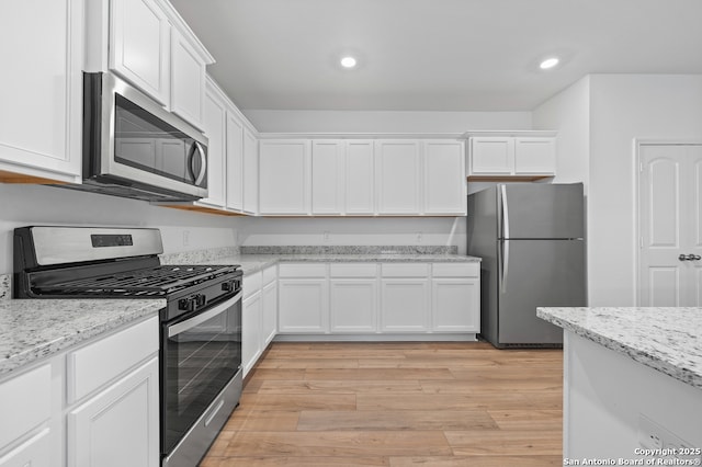 11502 Bald Eagle Hts, San Antonio, TX 78223 - kitchen featuring appliances with stainless steel finishes, white cabinets, recessed lighting, light wood-style flooring, and light stone countertops