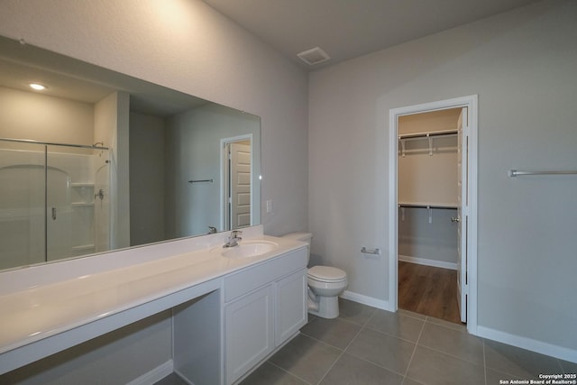 10310 Tule Creek Frk, San Antonio, TX 78252 - full bathroom featuring a shower stall, toilet, vanity, a spacious closet, and tile patterned floors