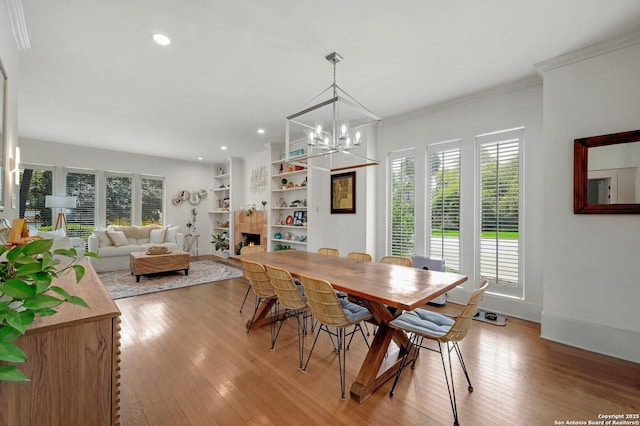 106 Mayflower, Alamo Heights, TX 78209 - dining room featuring light wood-type flooring, a tiled fireplace, a chandelier, baseboards, and recessed lighting