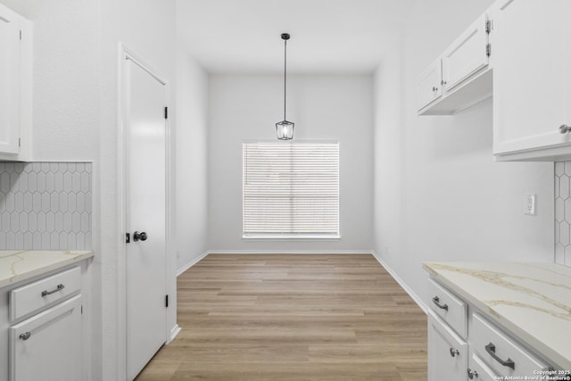 6610 Quail Lk, San Antonio, TX 78244 - unfurnished dining area featuring light wood-style floors and baseboards
