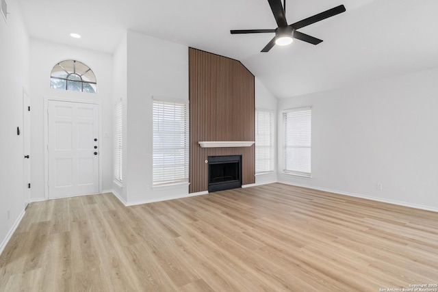 6610 Quail Lk, San Antonio, TX 78244 - unfurnished living room featuring light wood-style floors, ceiling fan, baseboards, a large fireplace, and vaulted ceiling