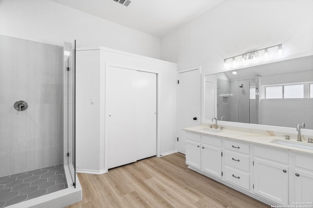 6610 Quail Lk, San Antonio, TX 78244 - bathroom featuring double vanity, a shower stall, and wood finished floors
