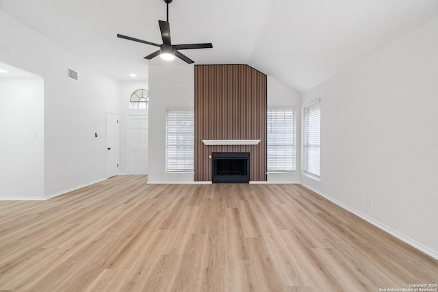 6610 Quail Lk, San Antonio, TX 78244 - unfurnished living room featuring light wood-style flooring, ceiling fan, lofted ceiling, baseboards, and a large fireplace