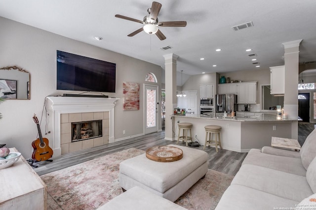 13019 Rambling Oak, San Antonio, TX 78232 - living room featuring light wood-type flooring, decorative columns, ceiling fan, recessed lighting, and a tiled fireplace
