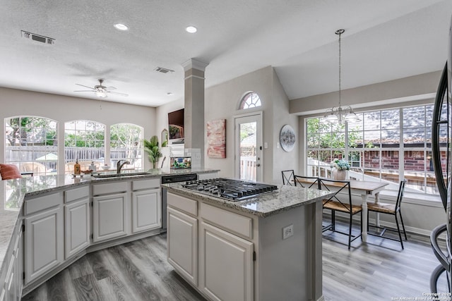13019 Rambling Oak, San Antonio, TX 78232 - kitchen featuring stainless steel gas stovetop, a sink, a center island, light wood finished floors, and a ceiling fan