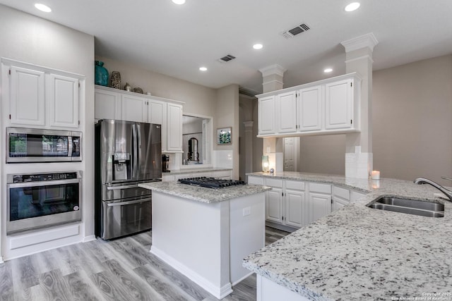 13019 Rambling Oak, San Antonio, TX 78232 - kitchen featuring stainless steel appliances, a sink, white cabinets, light stone countertops, and a center island