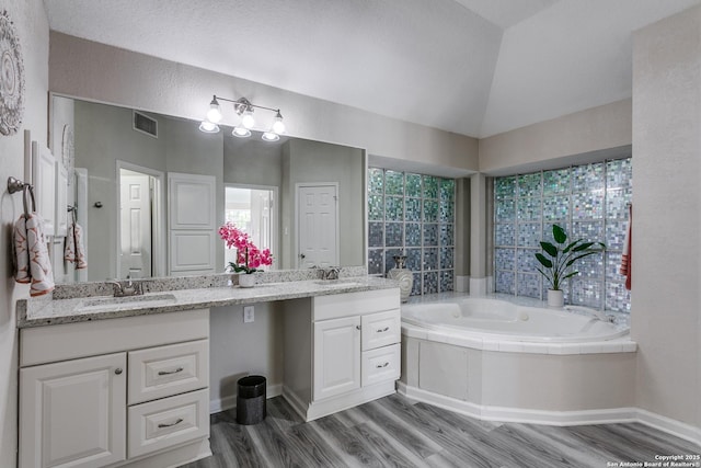 13019 Rambling Oak, San Antonio, TX 78232 - full bath featuring double vanity, a bath, wood finished floors, vaulted ceiling, and baseboards