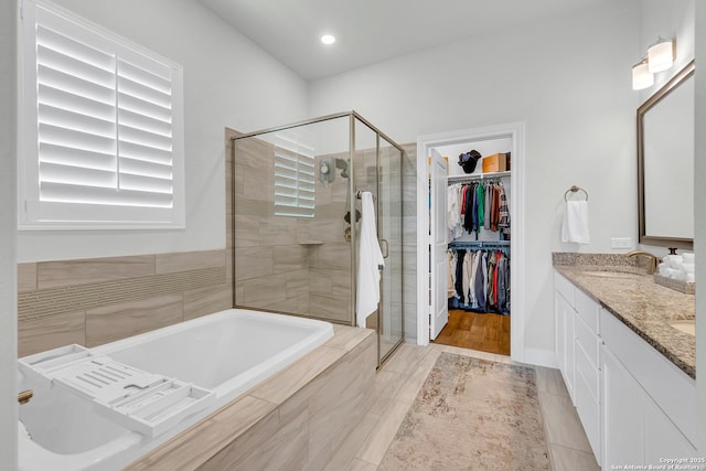 6827 Bella Verso, San Antonio, TX 78256 - full bathroom featuring a stall shower, a garden tub, a walk in closet, and double vanity