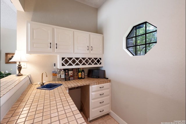 14706 War Admiral, San Antonio, TX 78248 - kitchen with tile countertops, a sink, white cabinetry, and light tile patterned floors